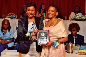 Dr. Monique Davidson-Tucker right on receiving her plaque Congress Woman Evet Clarke