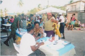 Job application and blood pressure screening at the Cimbux Job Fair in Buxton, Guyana